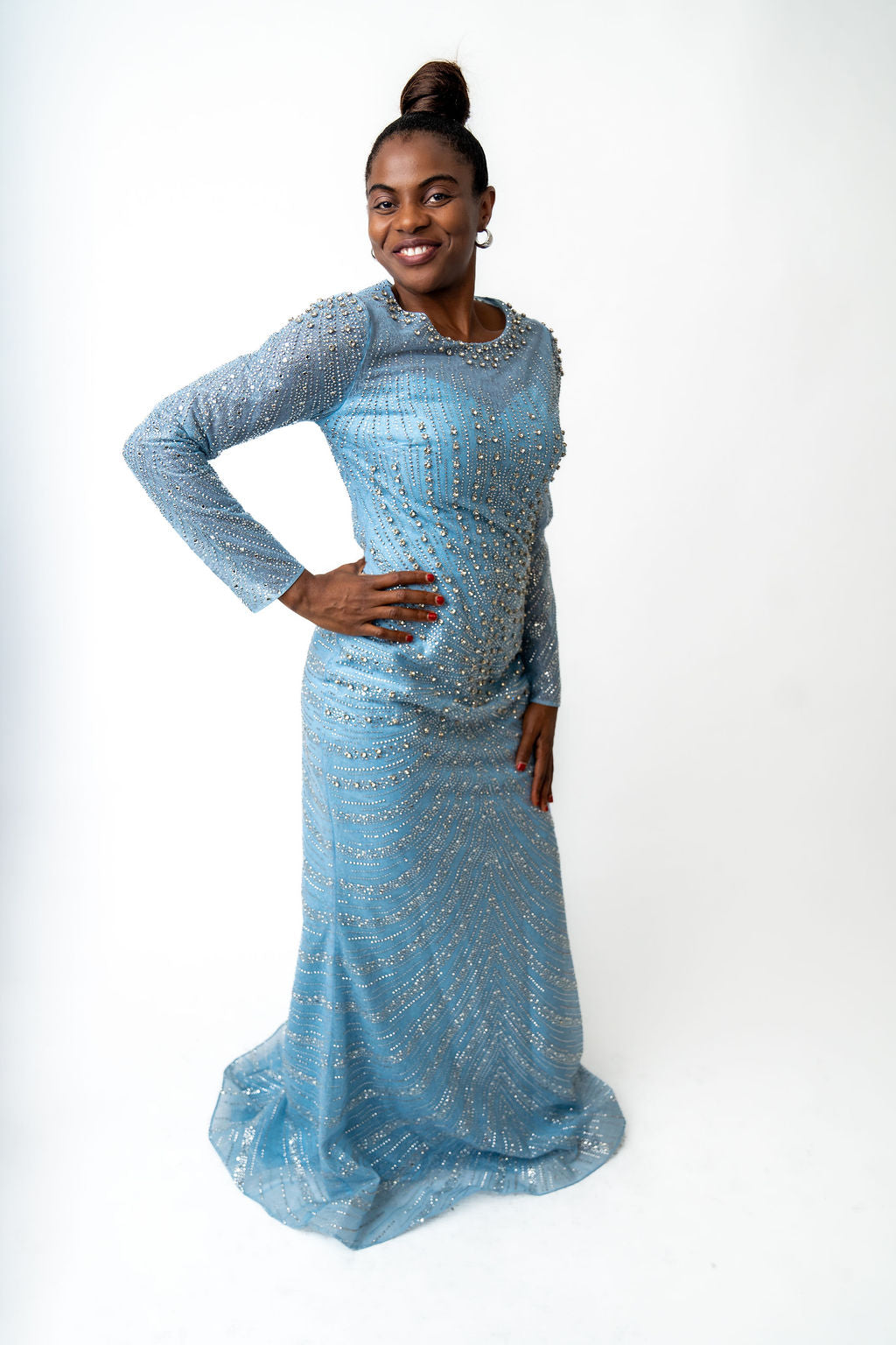Woman wearing a light blue beaded dress on a white background