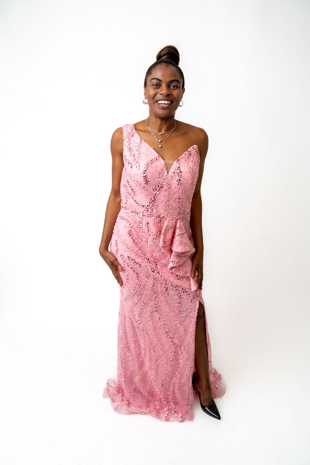 Woman wearing a pink sequin dress on a white background