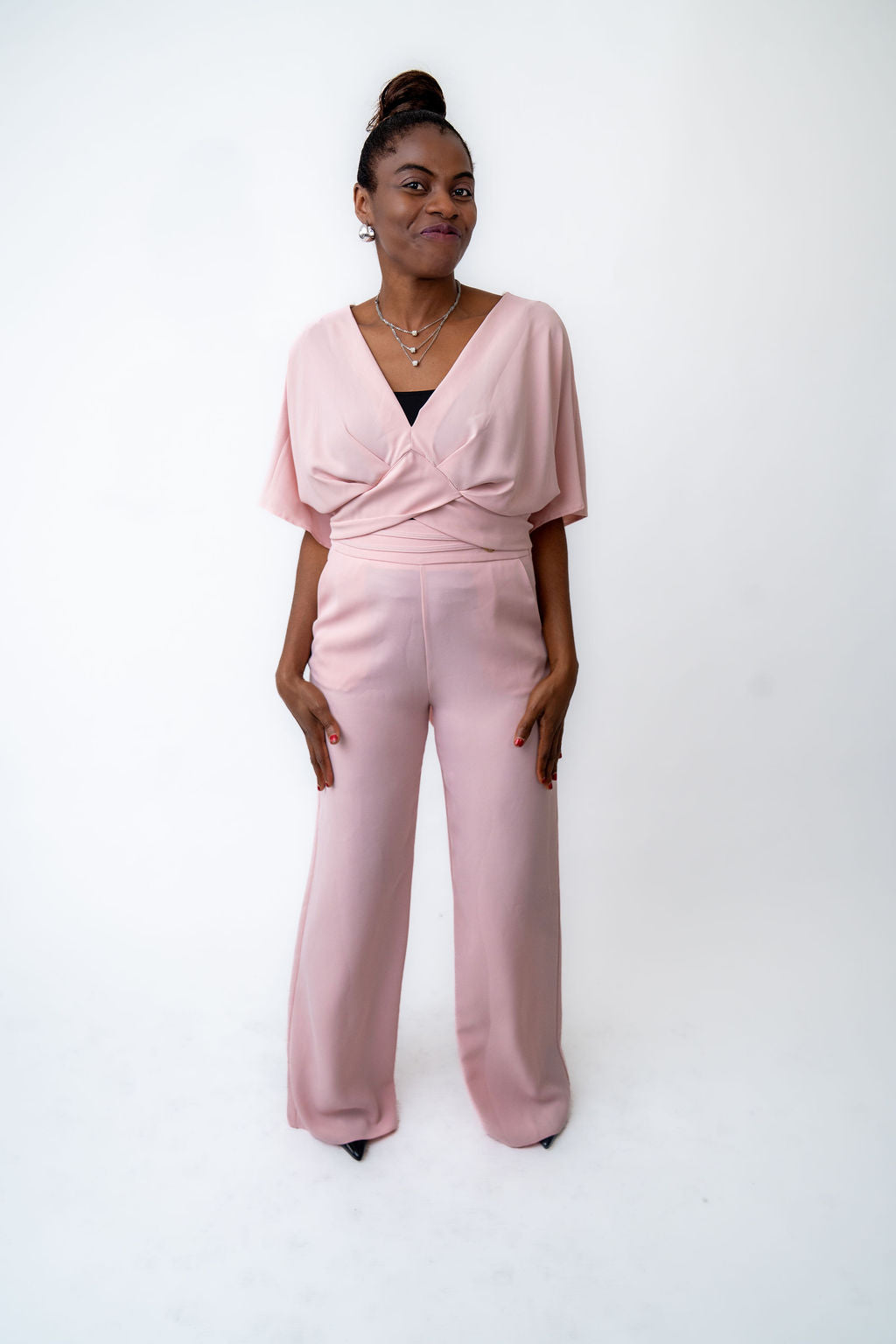 Woman wearing a pink jumpsuit on a white background