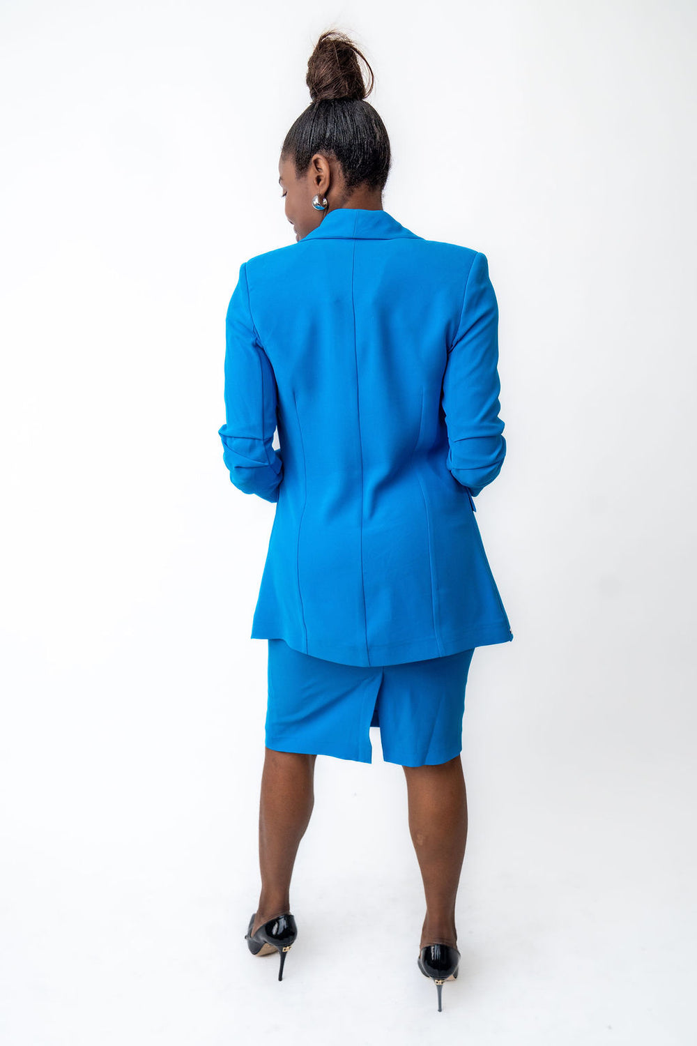Person wearing a blue suit standing against a white background