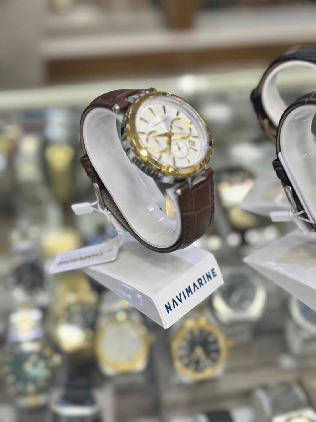 Navimagine watch on display with a blurred background of other watches.